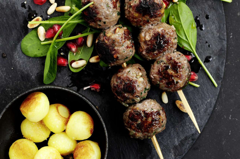 Brochettes de viande hachée d’agneau sur salade d’épinards