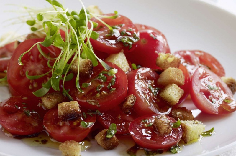 Salade de tomates avec croûtons à l’ail et sauce miel-cresson