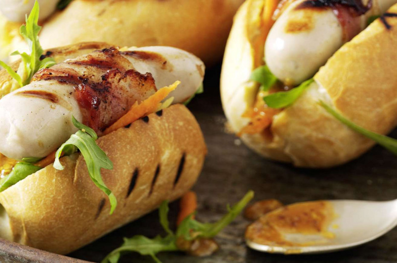 Hot-dog avec chipolata enrobée de lard grillé