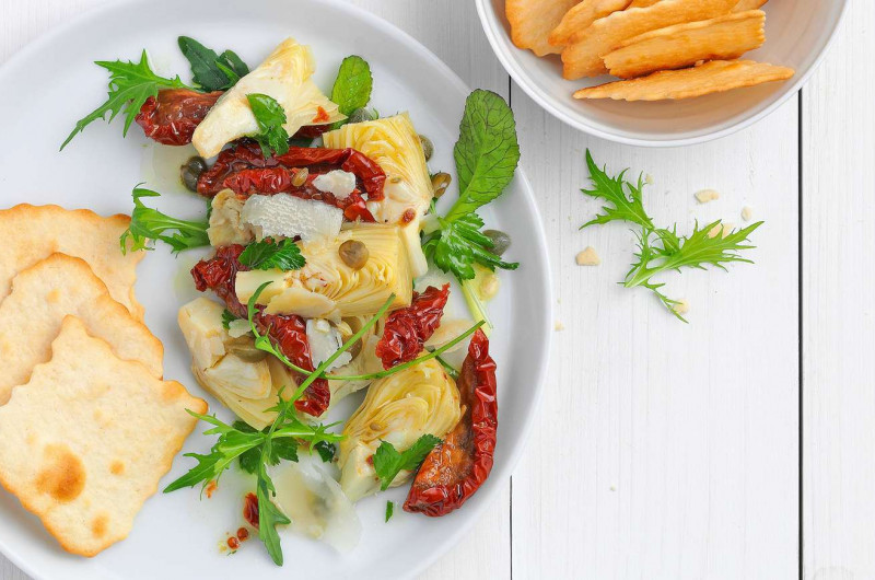 Crackers avec salade aux tomates séchées et aux artichauts